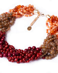 Collana girocollo a treccia con sfere in acrilico sui toni rossi ed arancio - Mya Accessories