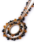 Collana lunga in tessuto con pendente, ricoperto di microcristalli in vetro arancio e nero - Mya Accessories