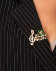 Spilla in metallo con design a forma di nota musicale natalizia con pietre in vetro crystal - Mya Accessories