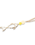 Collana lunga con pendente a forma di pesce e inserti bianco e giallo