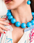 Collana girocollo in acrilico XXL azzurro con rondelle in ottone