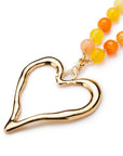 Collana lunga con pietre dure multi arancio e pendente in metallo a forma di cuore - Mya Accessories