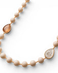 Collana lunga con pietre in resina beige ed inserti a goccia arancio