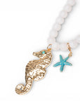 Collana lunga con sfere bianche in acrilico e pendente cavalluccio marino in metallo - Mya Accessories