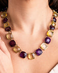 Girocollo in metallo colore bronzo, con pietre in resina trasparenti viola e giallo - Mya Accessories