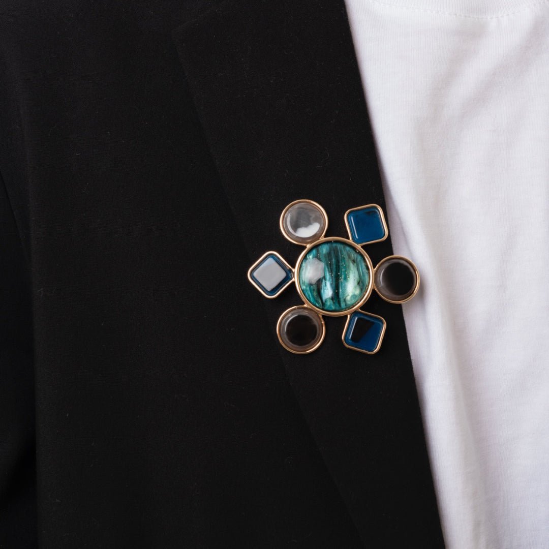 Spilla con base in metallo a forma di fiore geometrico in acrilico tono blu - Mya Accessories