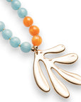 Collana lunga con sfere in acrilico arancio e turchesi, pendente a foglia - Mya Accessories