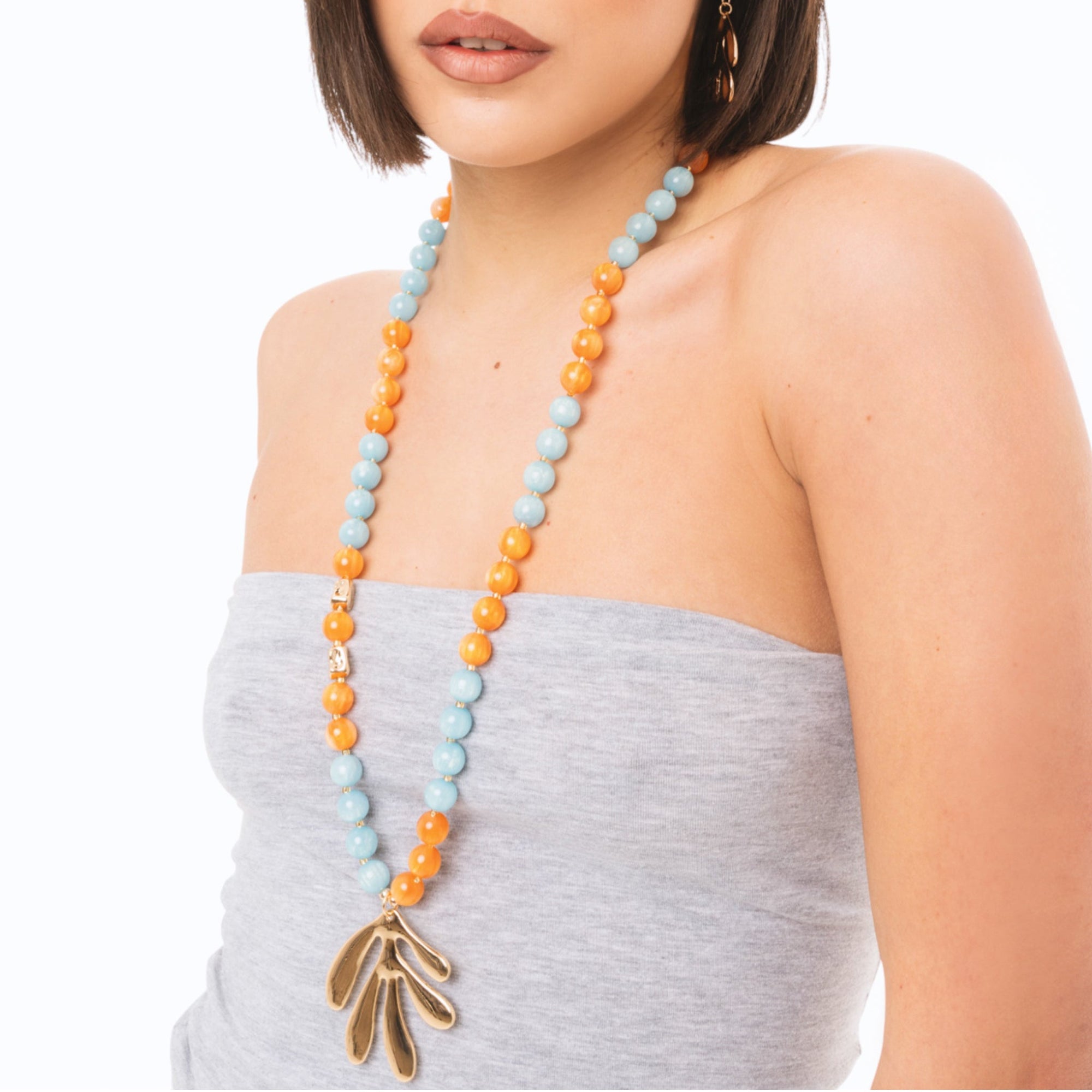 Collana lunga con sfere in acrilico arancio e turchesi, pendente a foglia - Mya Accessories