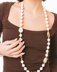Collana lunga con pietre in resina beige ed inserti a goccia arancio